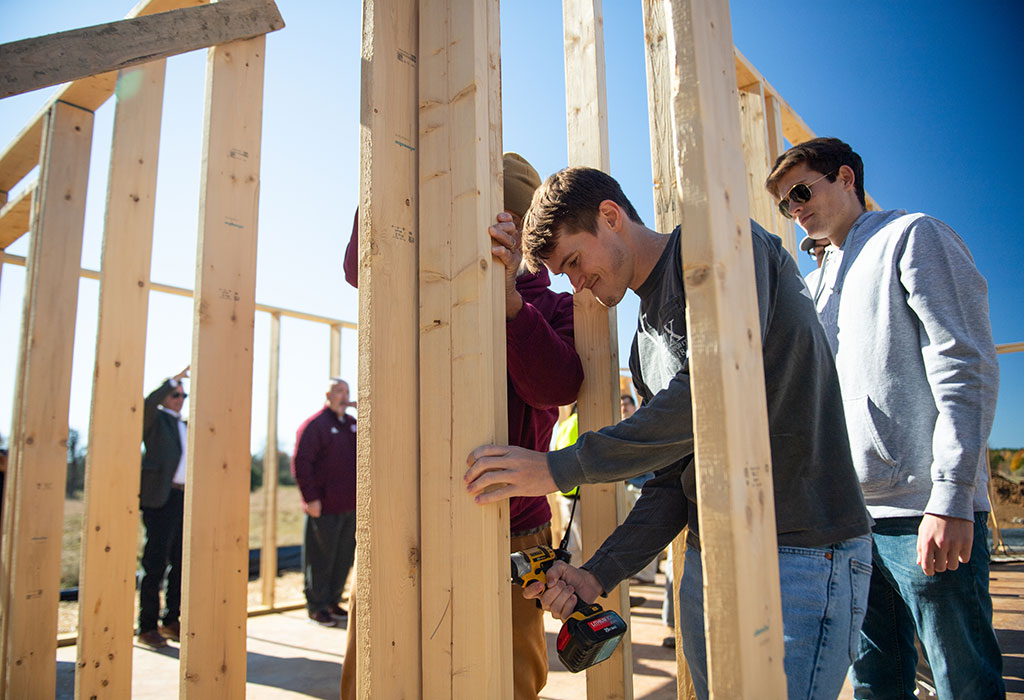 Volunteers help secure a wall frame during the groundbreaking of the Kelly Estates in November 2022.