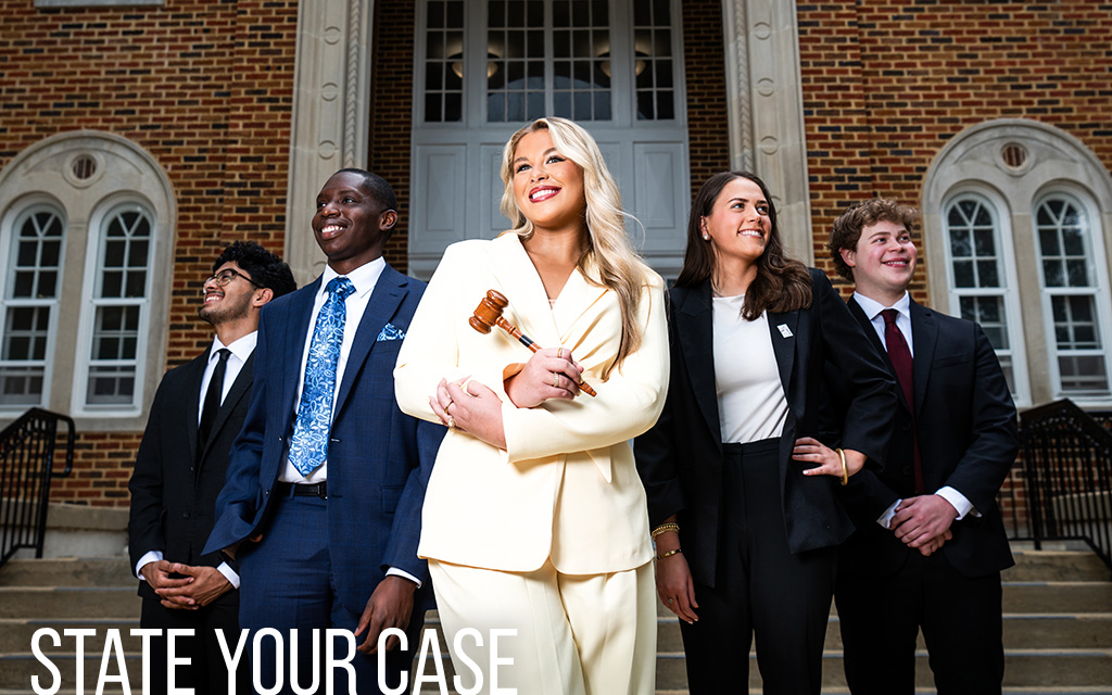 Five professionally dressed young adults stand in front of a brick building; the woman in the center holds a gavel and smiles confidently. Text reads "STATE YOUR CASE.