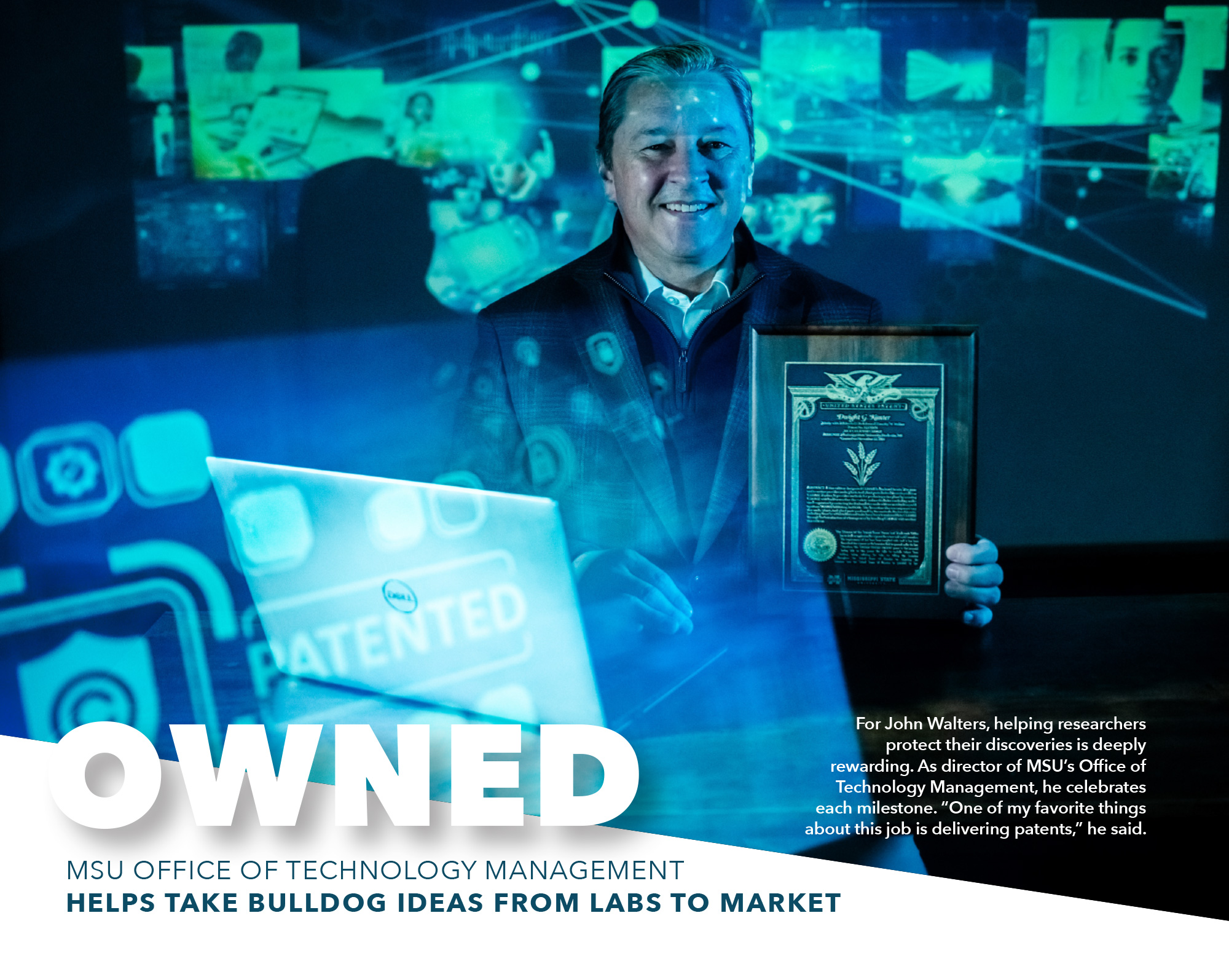 A man in a suit holds a framed patent plaque, standing by a table with projected patent images and text about MSU Office of Technology Management.